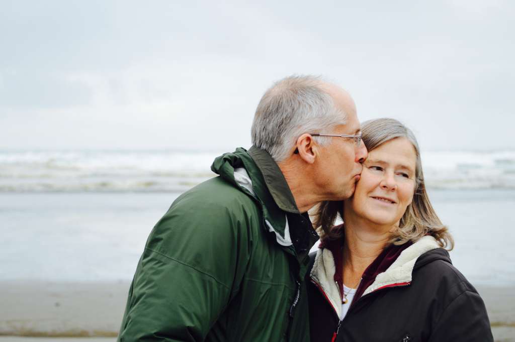 Older couple kissing on the beach to symbolize longevity